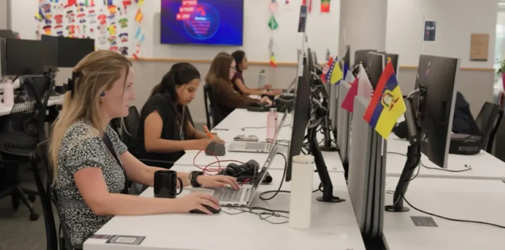 Trabajadoras en ciberseguridad con computadoras en una oficina moderna.
