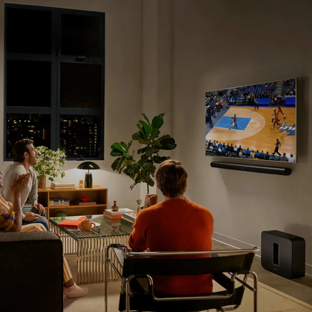 Sistema Sonos de cine en casa con barra Arc Ultra, Sub 4 y bocinas traseras en una sala.
